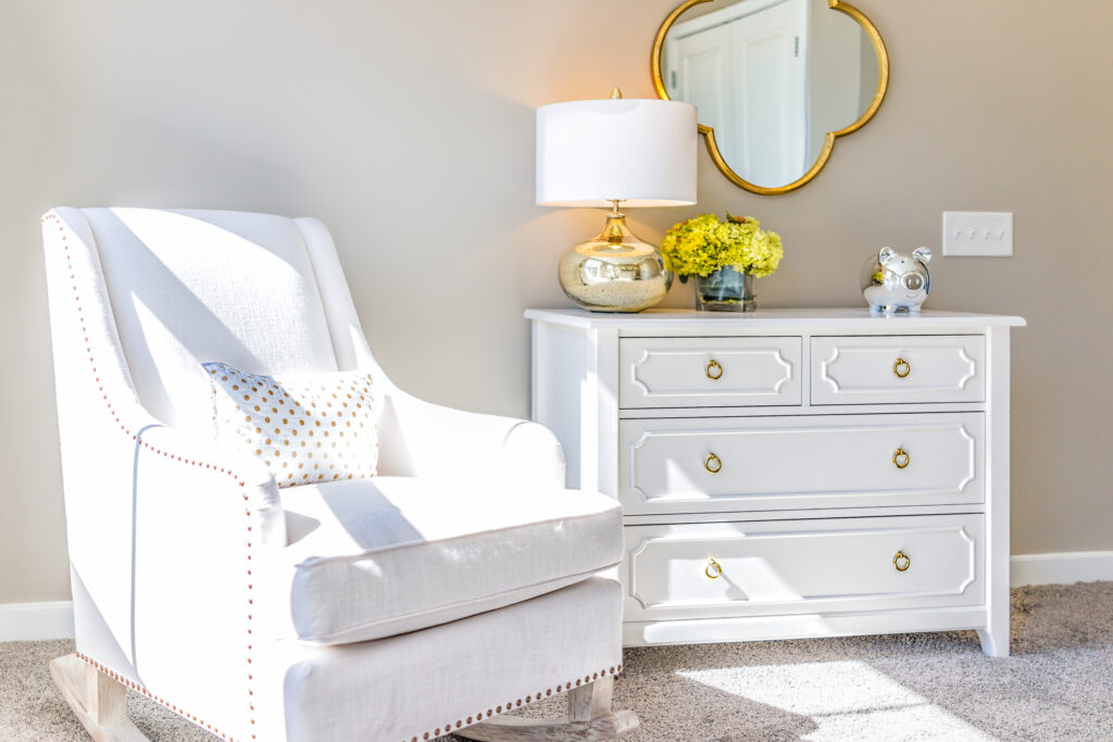 all white dresser and chair with light flooring and walls