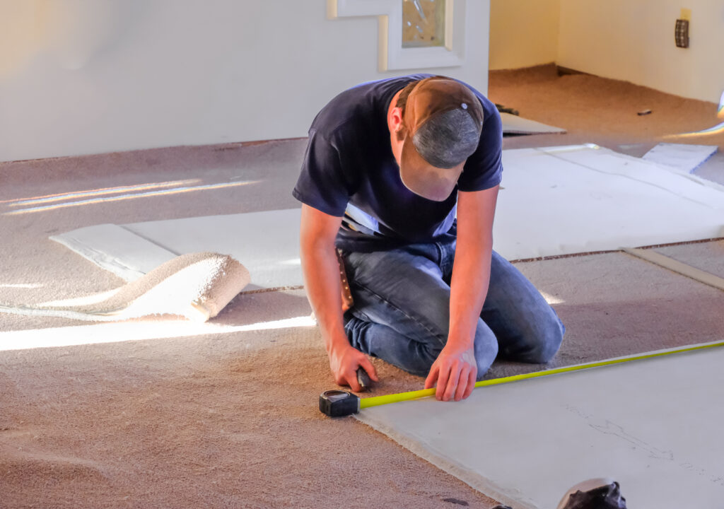 installer measuring carpet for installation